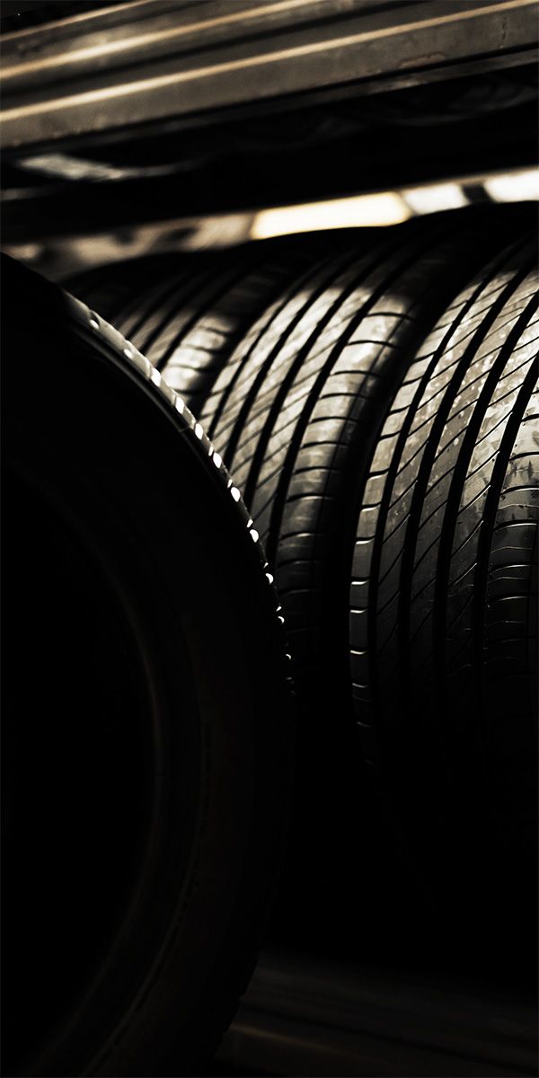 Reifen die nebeneinander in Regalen gelagert sind.